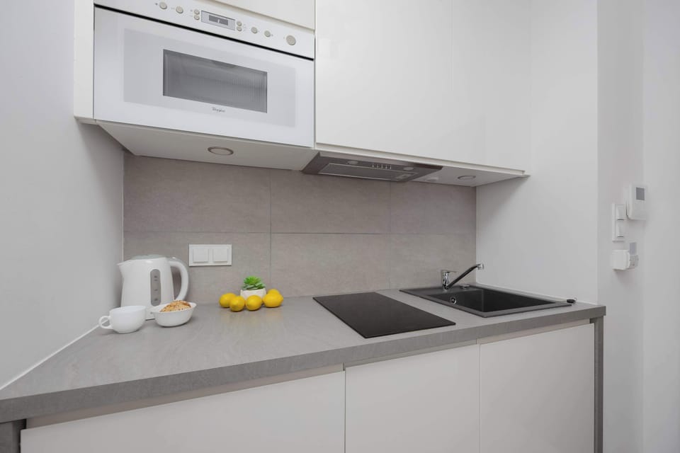 The kitchenette with an electric hob, kettle, and microwave makes meal preparation easy and convenient.
