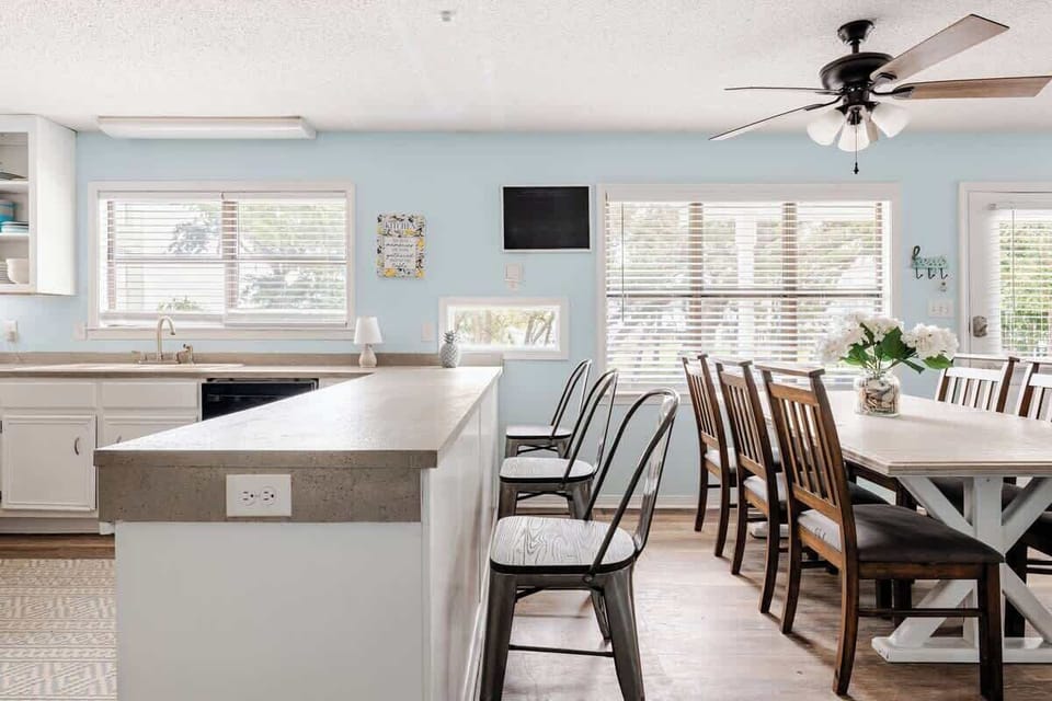 Bright and spacious kitchen with ample counter space, open shelving, double oven, and a breakfast bar fully equipped for easy meal prep and family gatherings.