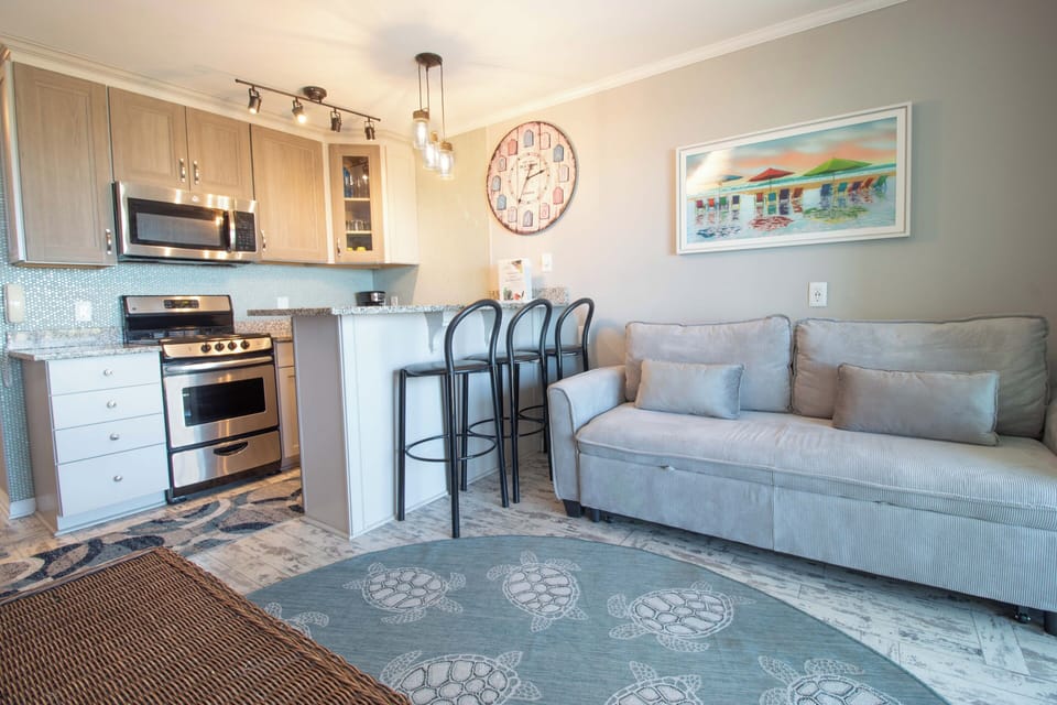 You'll love this bright, coastal-inspired space where kitchen, dining, and living areas flow together. Settle into the plush sofa, whip up meals with modern appliances, and enjoy the beachy vibe throughout.