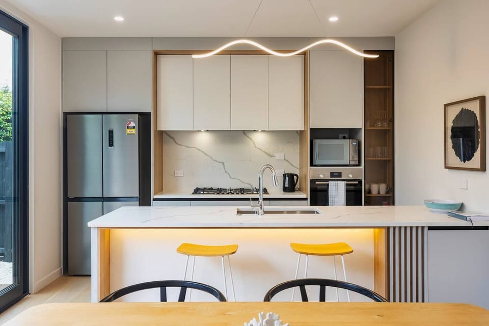 Open plan kitchen and dining, with lounge seating and sliding doors opening out to a deck and patio. Heated and cooled with Air-conditioning.