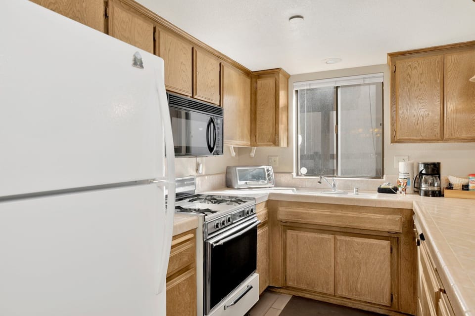 Fully equipped cabin kitchen with ample cabinetry, stove, fridge, microwave, and coffee maker—perfect for cooking meals, morning coffee, and feeling right at home on your stay.