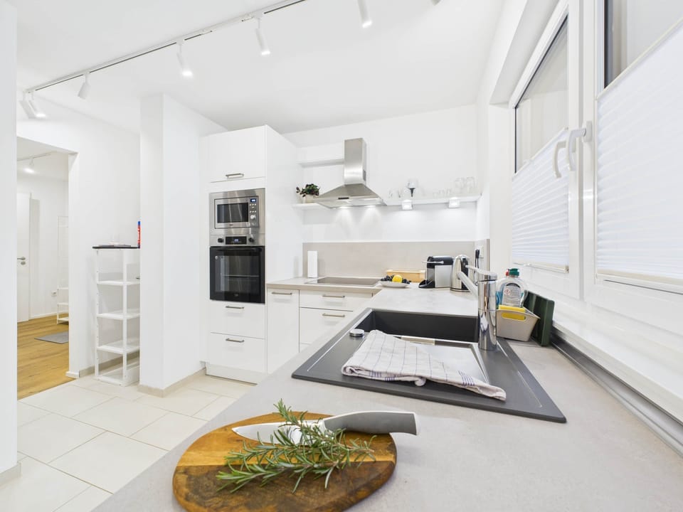 Modern, bright, fully equipped kitchen with an oven, microwave, and plenty of counter space.