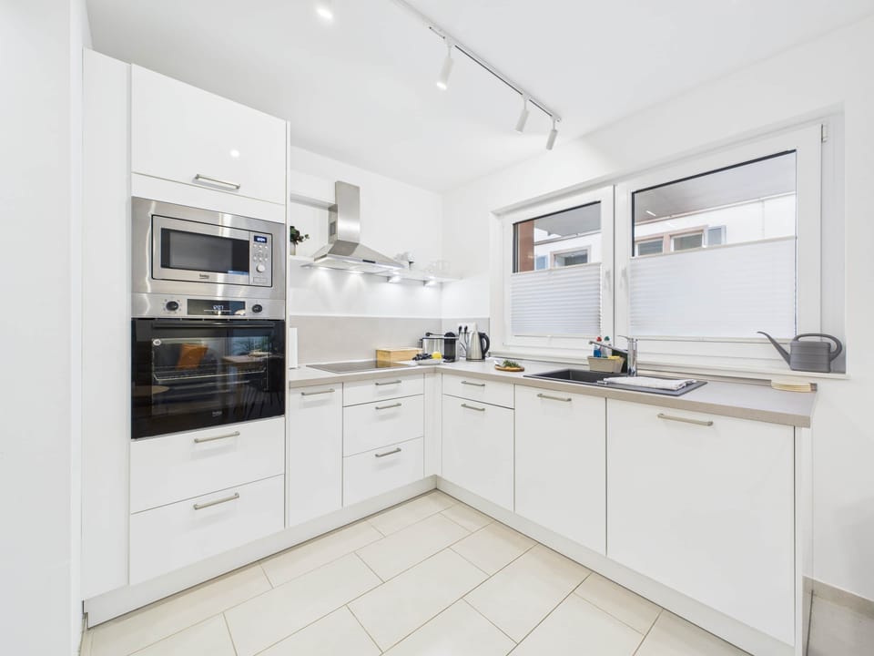 Open, fully equipped kitchen with clean lines and high-quality fittings.