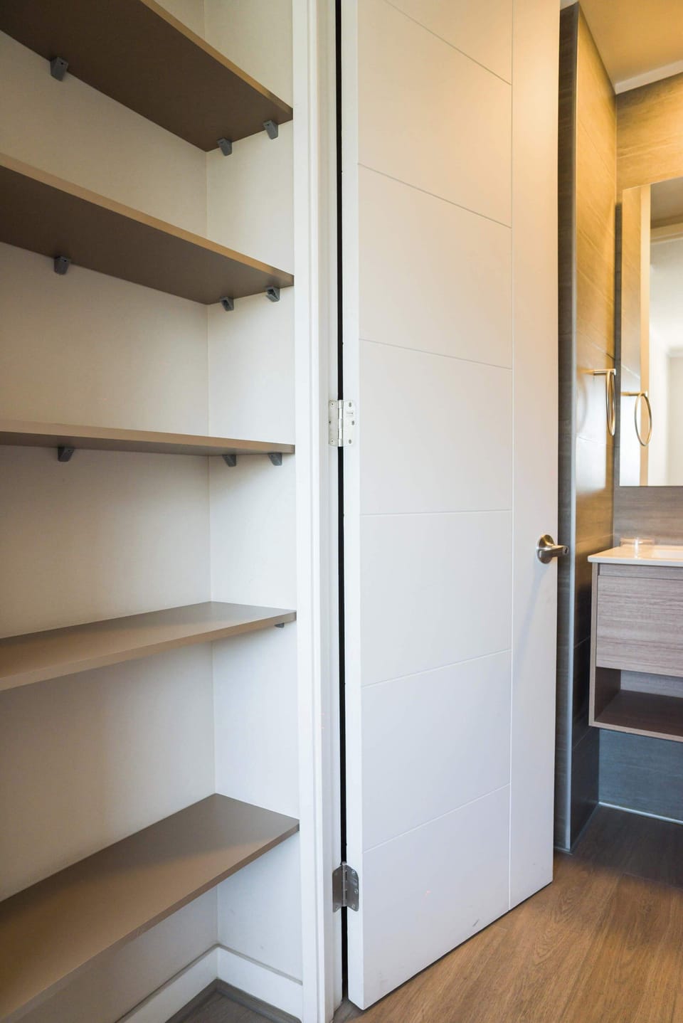 Sleek bathroom with ample shelving and modern design, offering both style and functionality for your stay.