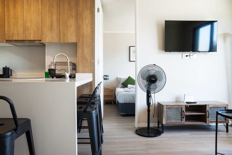 Modern kitchen with sleek design and a cozy view into the bedroom, perfect for a relaxing stay.