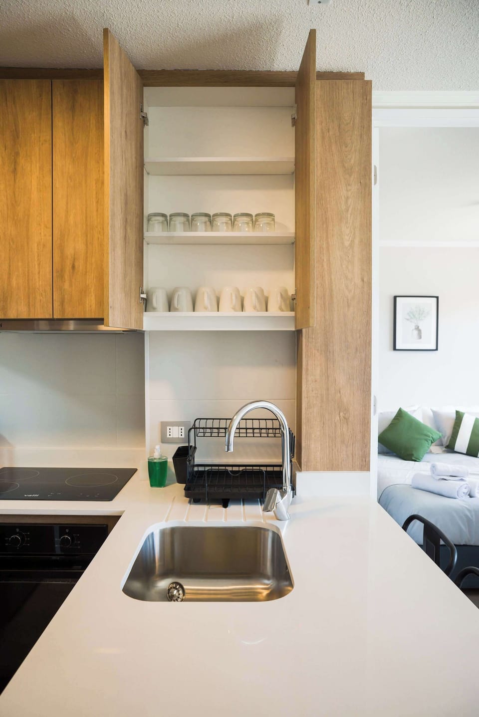 Modern kitchen with sleek amenities and a cozy bedroom view, perfect for a comfortable stay.