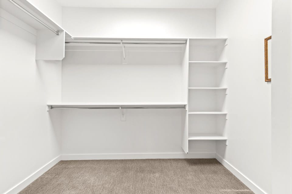Your walk-in closet offers generous hanging space on dual rods and built-in shelving to keep everything organized and accessible during your stay.