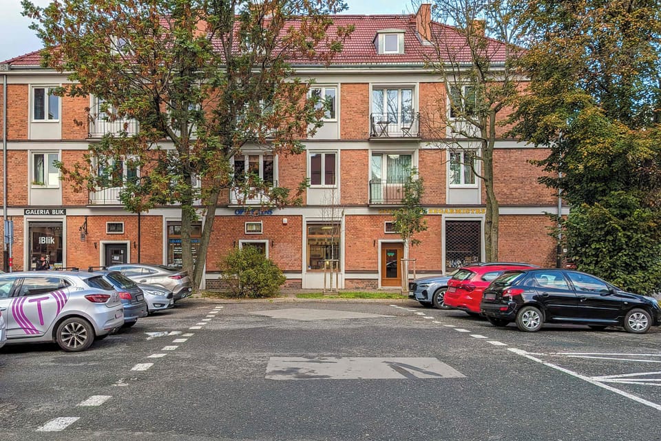 Apartment building with a quiet street and trees just behind the apartment.