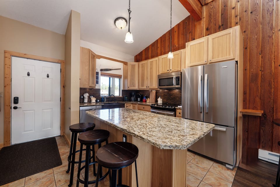 Your fully equipped kitchen features granite counters, stainless appliances, and a breakfast bar where you can enjoy morning coffee.
