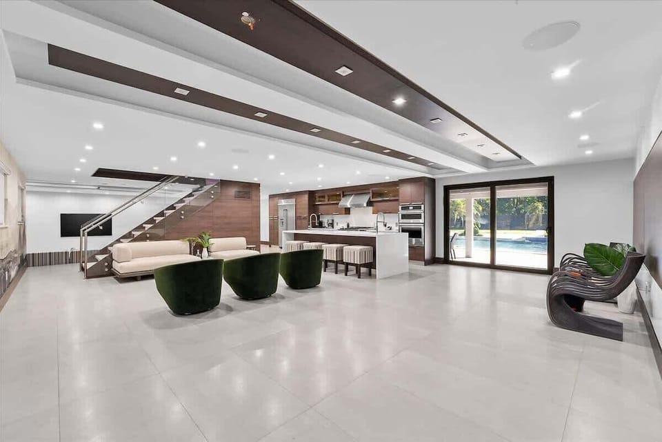 Spacious open-concept living area with smart TVs and designer furnishings.