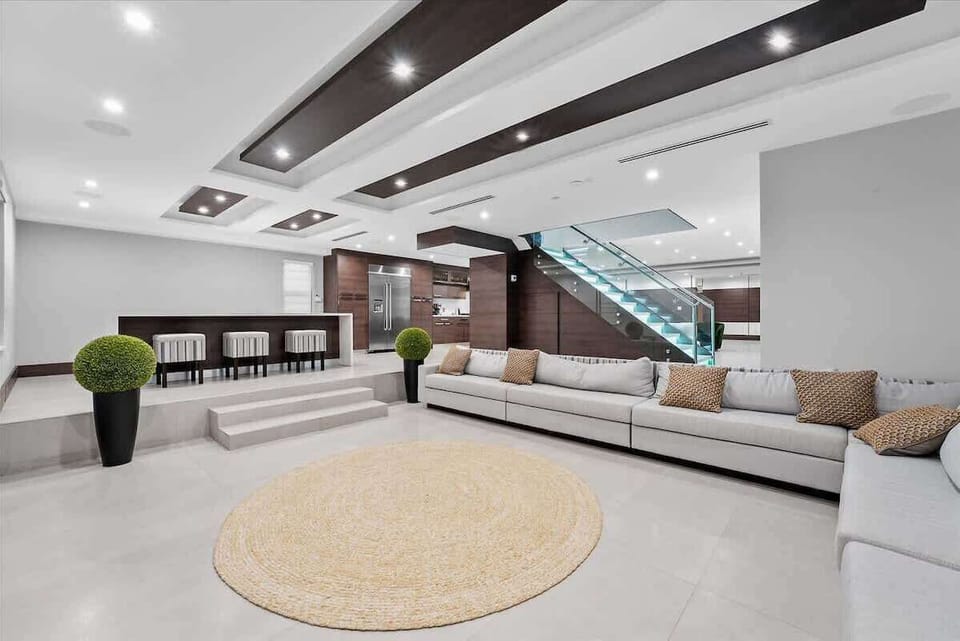 Spacious open-concept living area with smart TVs and designer furnishings.