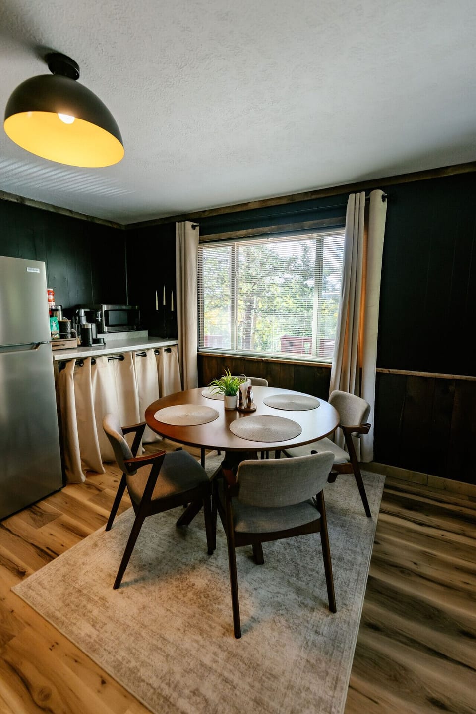 Dining room comfortable seats 4 and hides the washer and dryer behind the curtains
