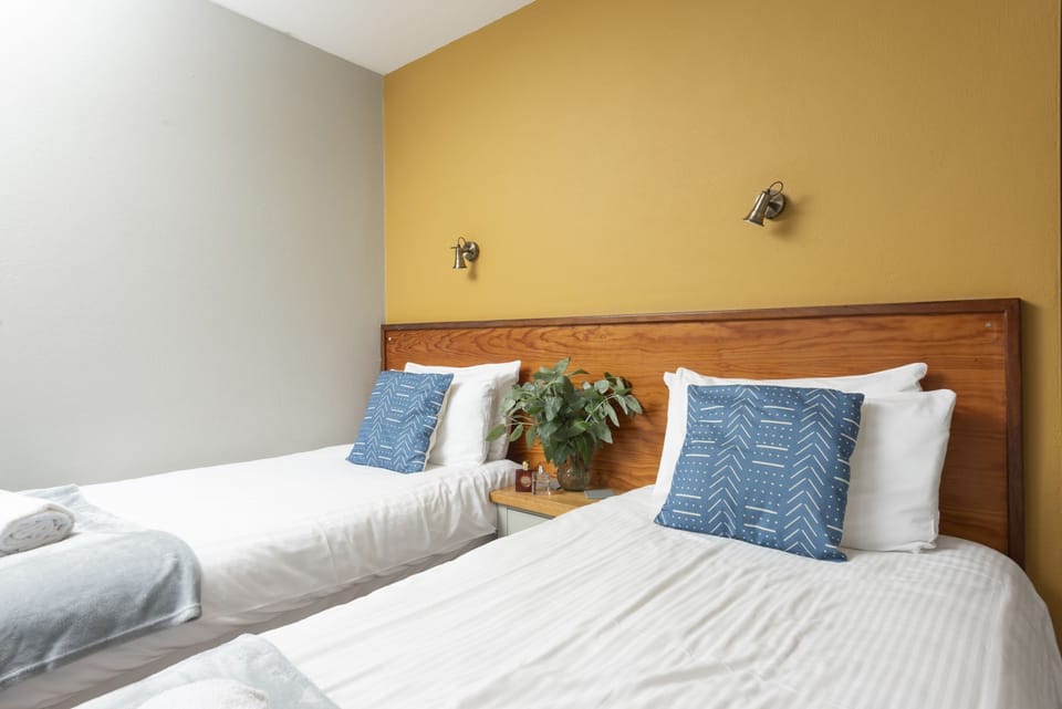 Twin beds with bedside table and overhead reading lamps