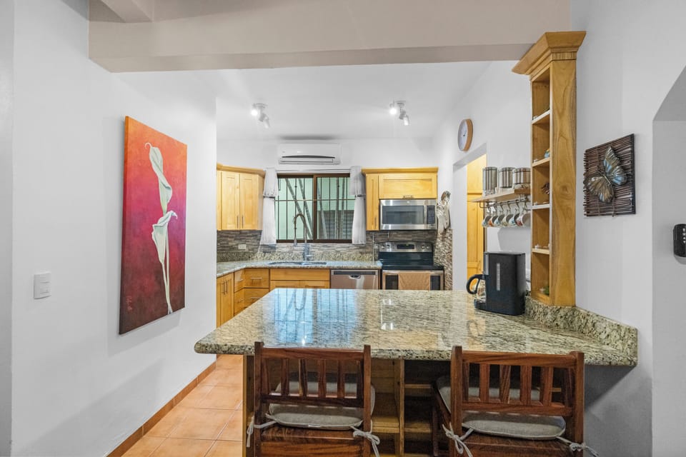The large kitchen has stainless steel appliances and a breakfast bar for 2.