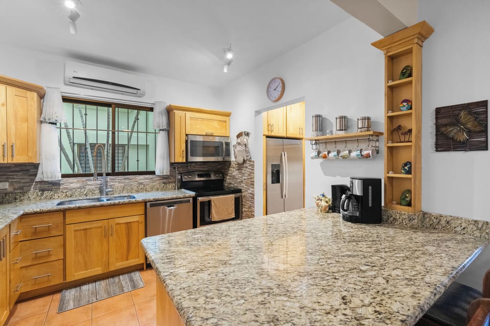 The large kitchen has stainless steel appliances and a breakfast bar for 2.