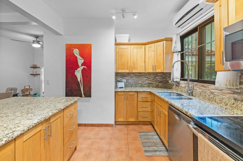 The large kitchen has stainless steel appliances and a breakfast bar for 2.
