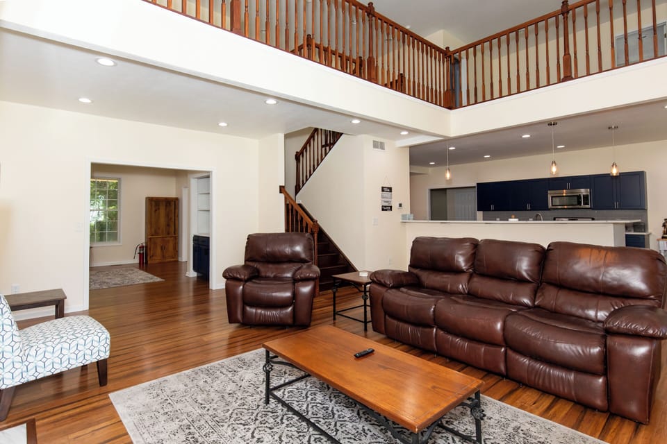 Stretch out in this open-concept living space where rich wood floors and soaring ceilings create an airy, welcoming feel. Your kitchen and cozy seating flow together effortlessly.