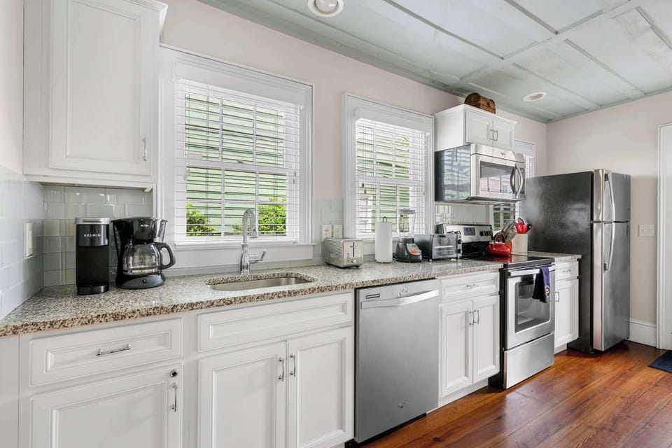 Fully equipped kitchen stocked with modern appliances, cookware, and complete diningware.