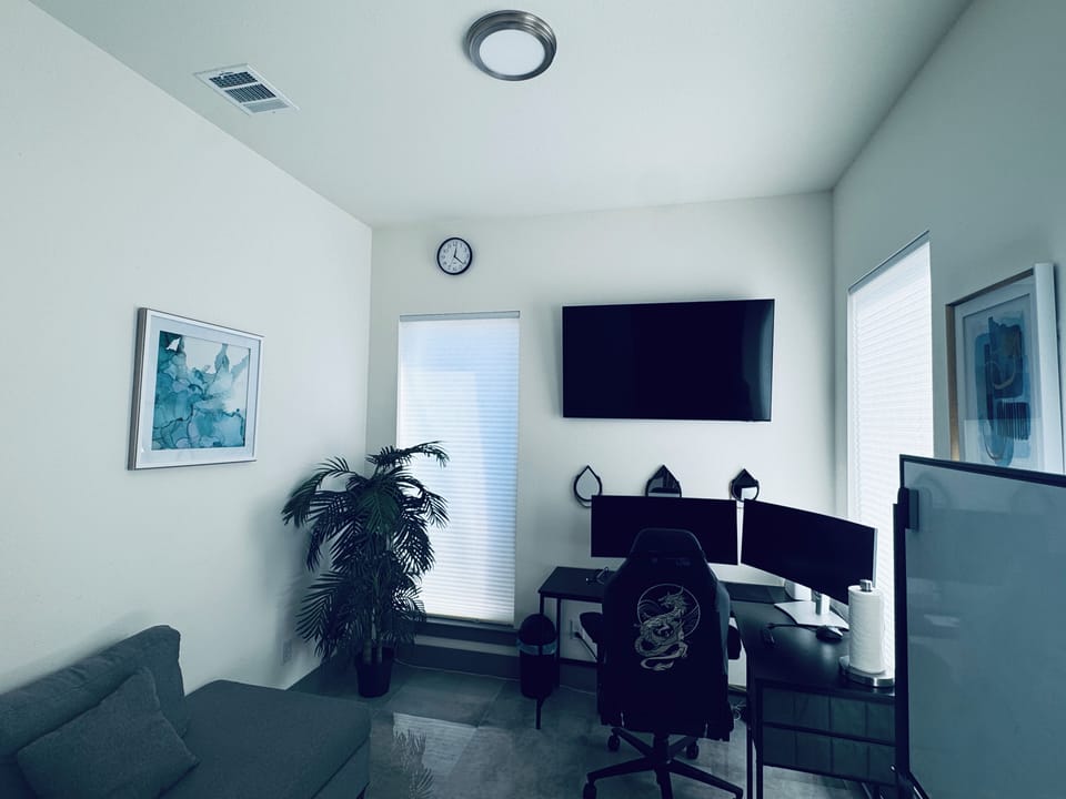 Office with desk, chair, 2 monitors, white board and sofa