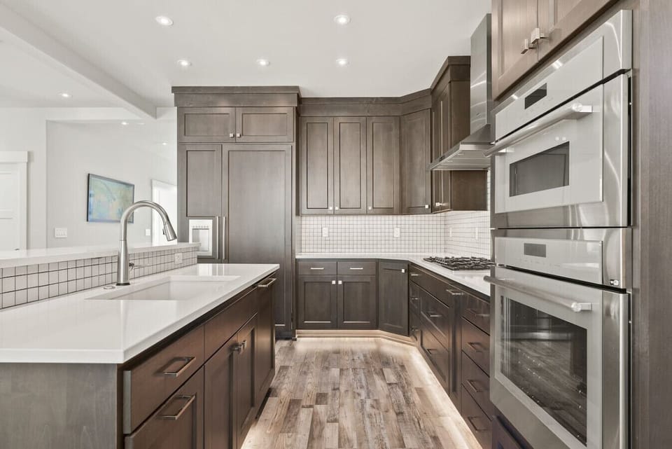 Gourmet kitchen with double ovens, gas range, and elegant quartz countertops — perfect for preparing wine country dinners in style.