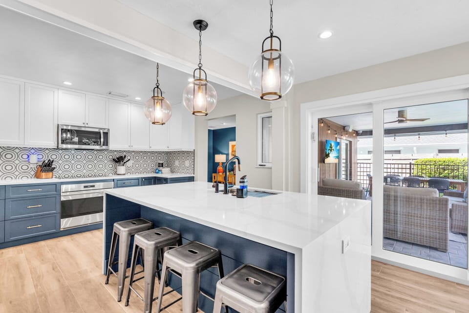 Kitchen with island seating, pendant lights, and blue cabinetry