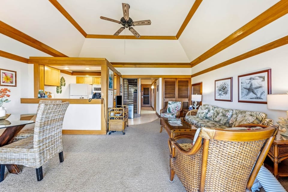unlit tropical living and dining area with warm wood accents and an open design.