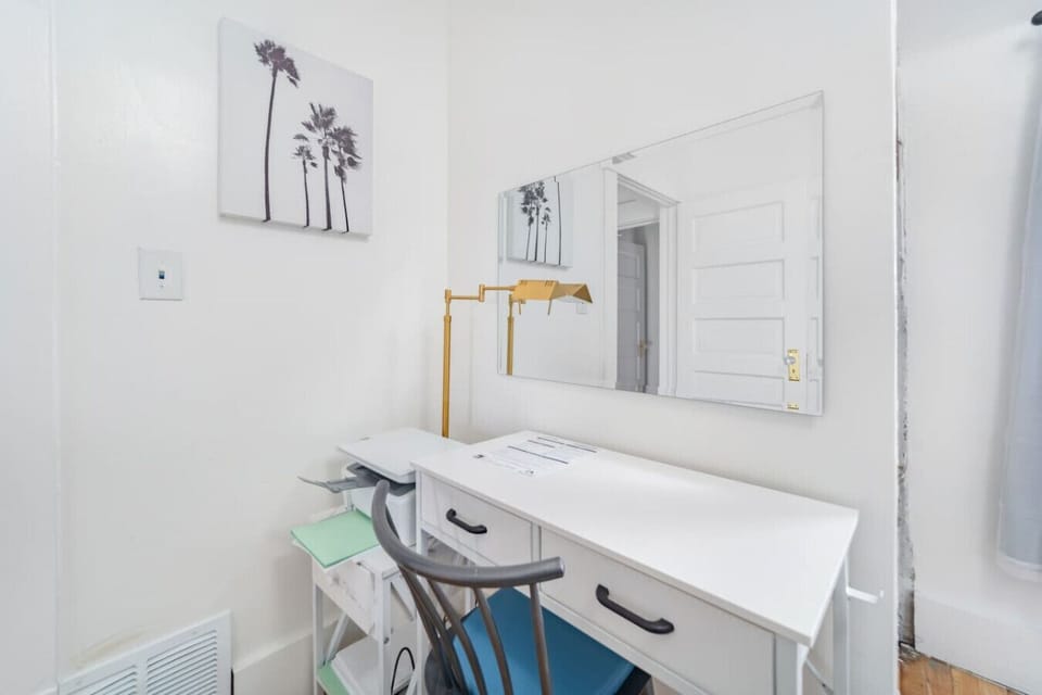 Whether you`re traveling for business or just need a quiet spot to plan your day, this bright, dedicated workspace has you covered. It features a clean white desk with storage drawers, a comfortable chair, and a gold task lamp for focused lighting.