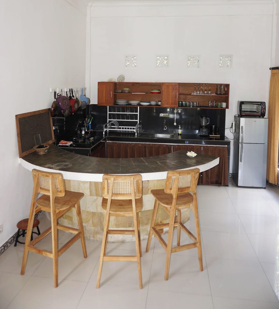 Fully equipped kitchen with tall chairs on the island