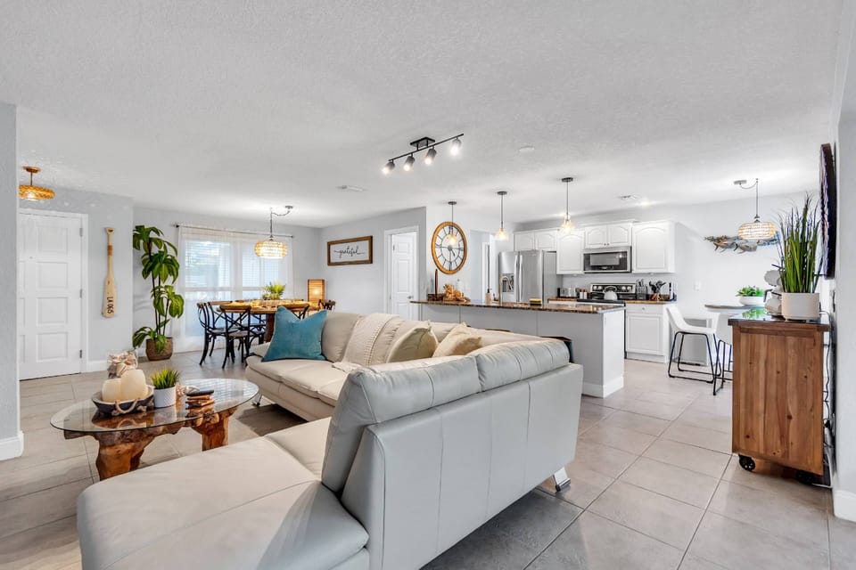 A large sectional sofa that will fit your entire family looking into the kitchen and dining room area