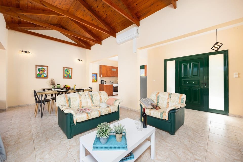 Open-plan living room with sofas, dining area, kitchen, ornamental fireplace, A/C, WiFi internet, and satellite TV