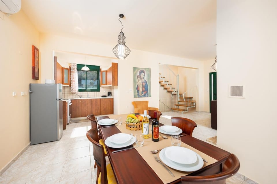 Open-plan living room with sofa, dining area, kitchen, ornamental fireplace, A/C, WiFi internet, and satellite TV