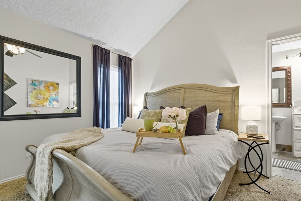 Bedroom 1 | King Bed with Decorative Pillows | Light Wood Sleigh Bed Frame | TV
