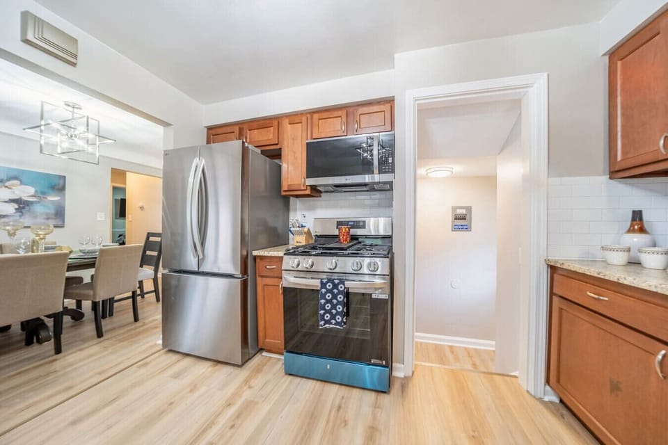Cook with ease in this updated kitchen featuring sleek stainless steel appliances, a modern gas range, plenty of counter space, and all tied together by stylish wood cabinetry.