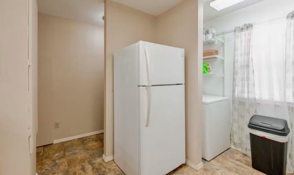 Bright, cozy kitchen w/ warm wood cabinets, white appliances, & place to unwind.