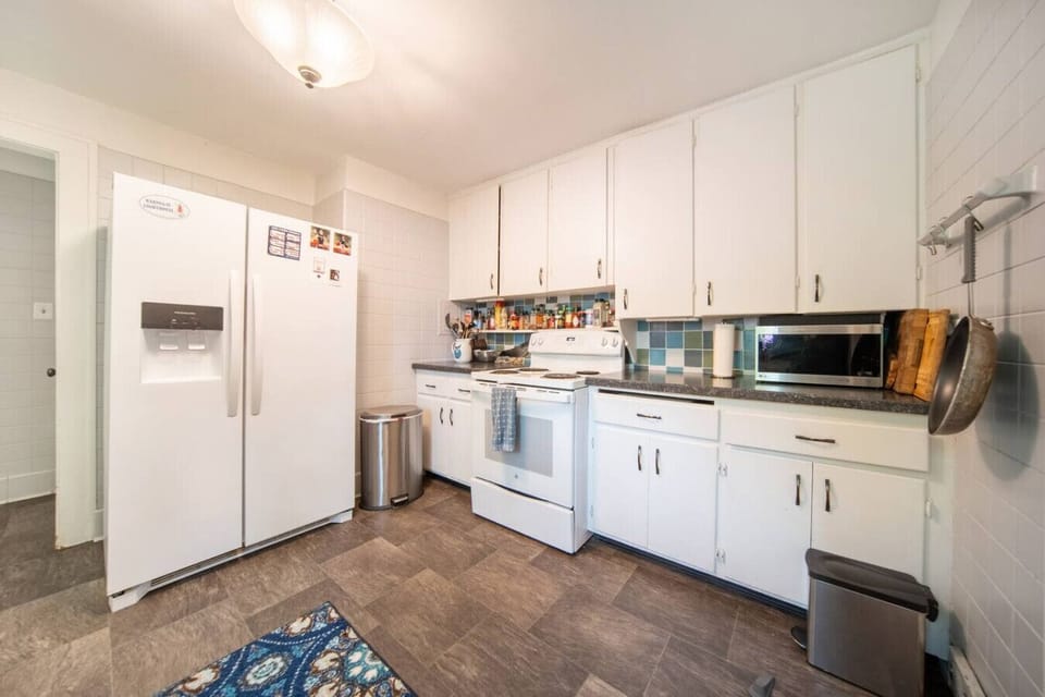 Prepare your favorite meals in this modern kitchen, featuring sleek stainless steel appliances, ample cabinet space, and bright recessed lighting.