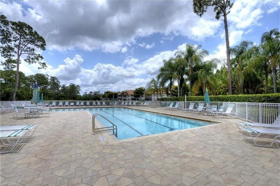 Resort-style pool with tropical landscaping and lounge areas for relaxing