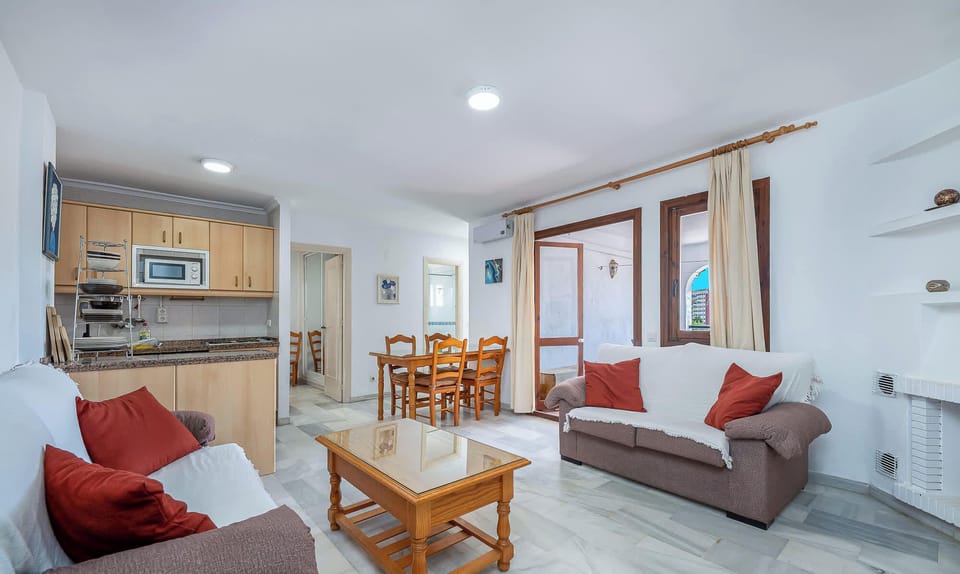 A room with a sofa, coffee table, and a dining table. A simple space room furniture.