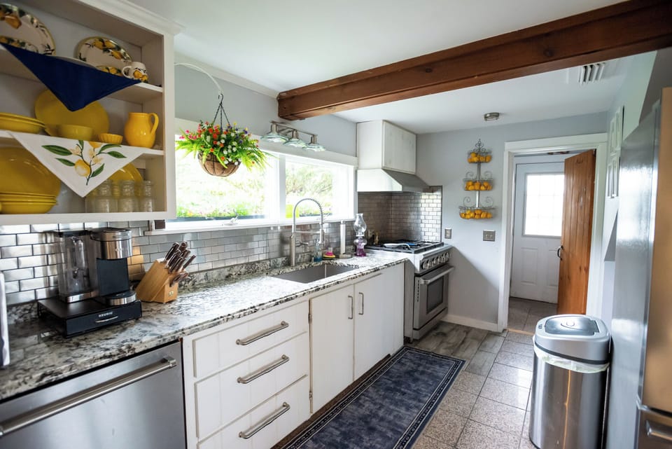 Kitchen with entrance to half bath and then outside deck beyond  that. 
