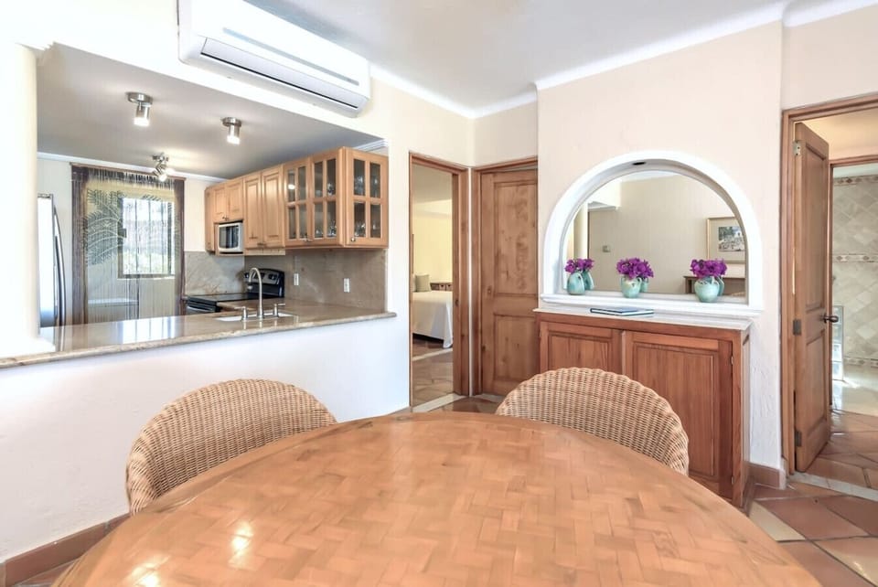 Warm dining space with wicker chairs, tropical decor, and natural light.
