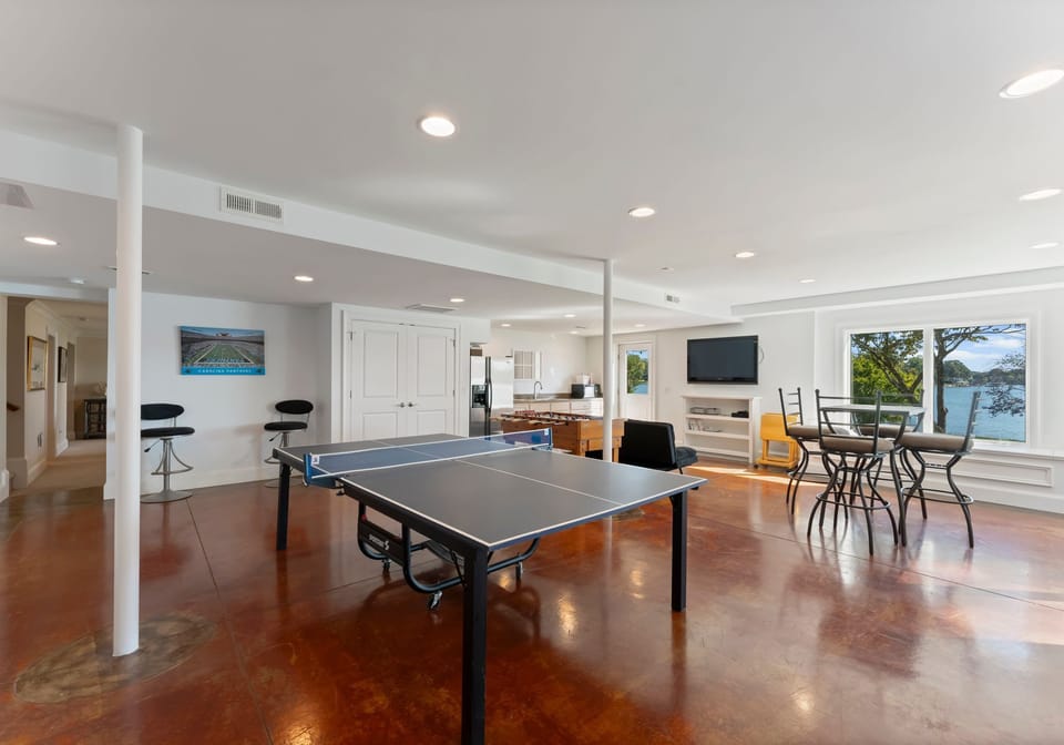 Lower Level game room with ping pong, foosball, air hockey, couch & TV. Plus wet bar with full size fridge.