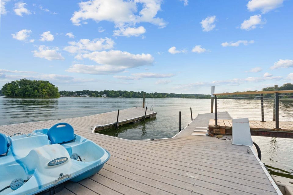 Dock with large swimming platform including a diving board and ladder and paddle boat for guests use.