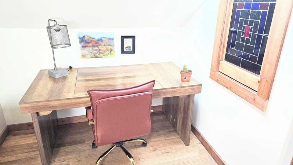 Work from home space, with large desk and comfy rolling leather rolling chair