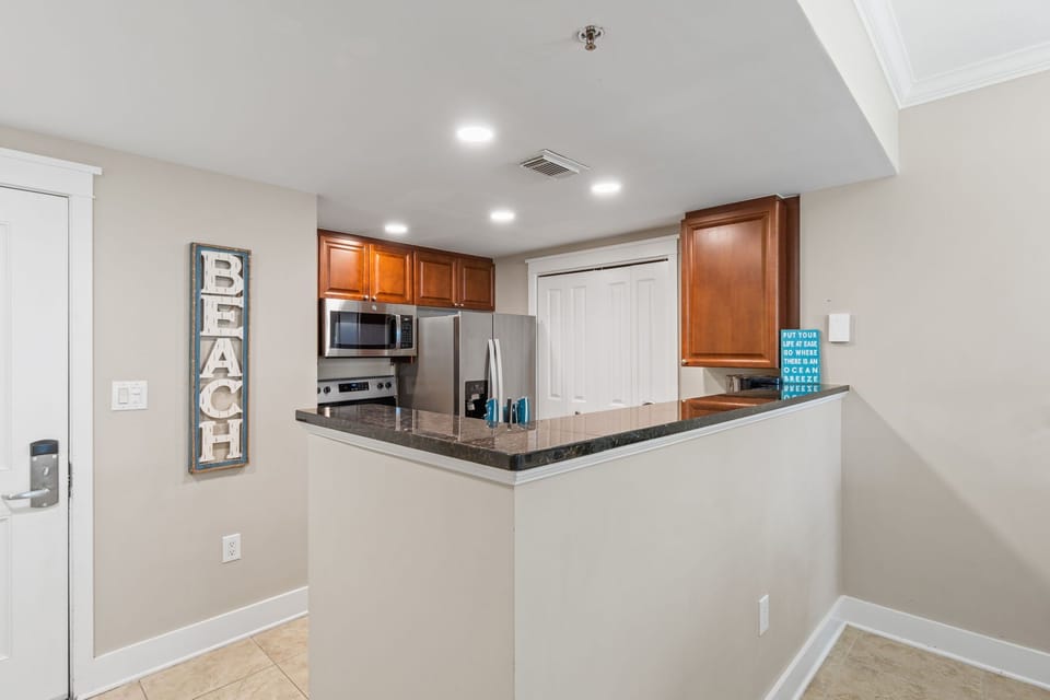 Bright and functional kitchen where you can prepare meals while enjoying a glimpse of the pool and beach from the balcony.
