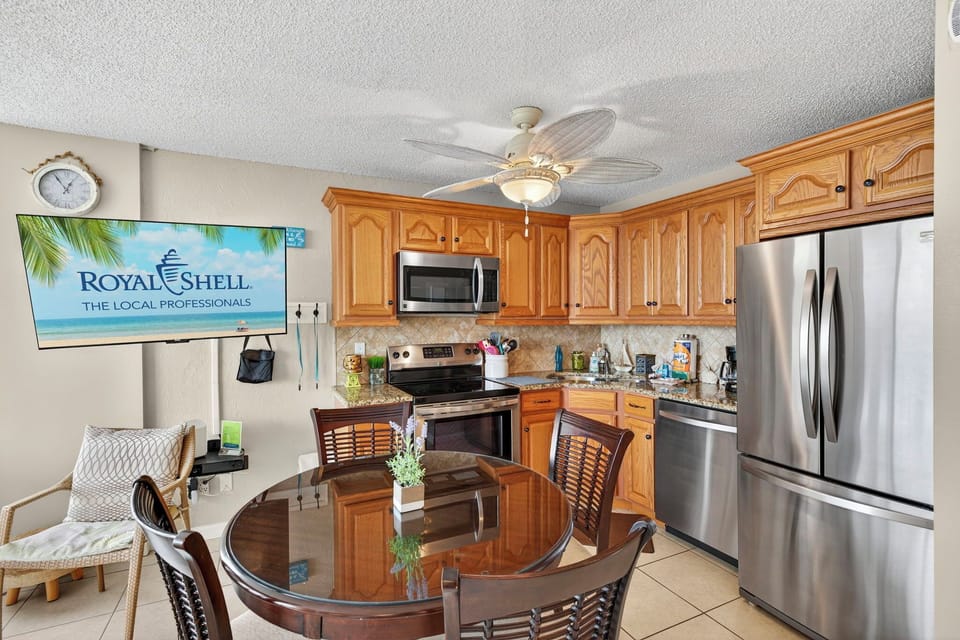 Fully equipped kitchen with stainless steel appliances and a cozy dining area—perfect for enjoying meals during your Fort Myers Beach stay at Estero Beach & Tennis Club.