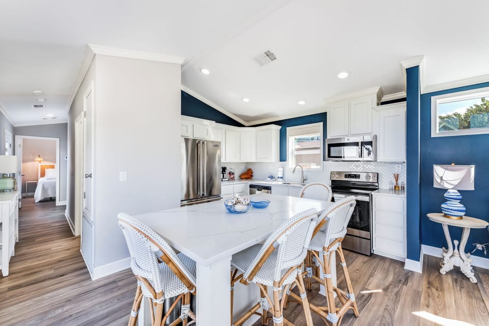 Your spacious kitchen features white cabinets, modern appliances, and a breakfast island where you can enjoy morning coffee.