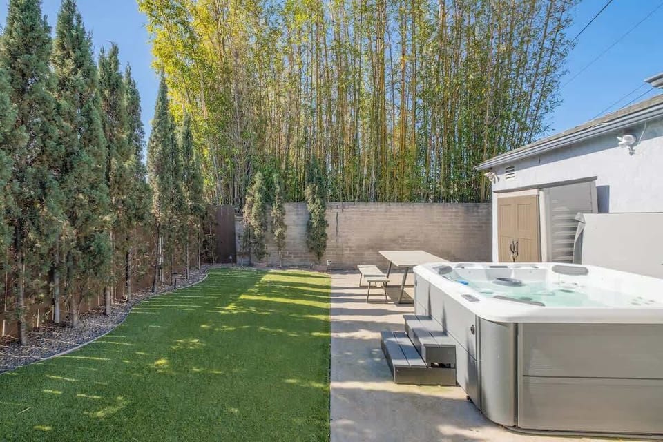 Relax in the inviting hot tub surrounded by tall bamboo and leafy pencil pines