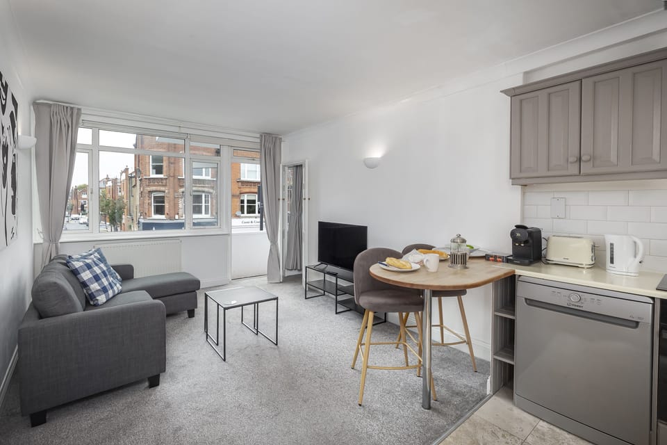 Open-plan living room with sofa, TV, and dining space.