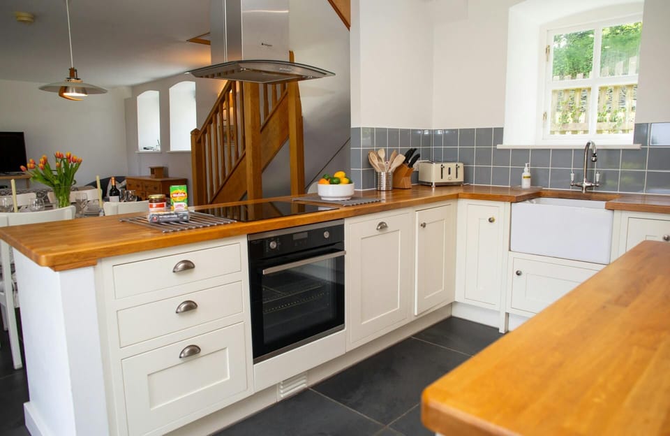 Kitchen area with electric hob, oven and extractor hood
