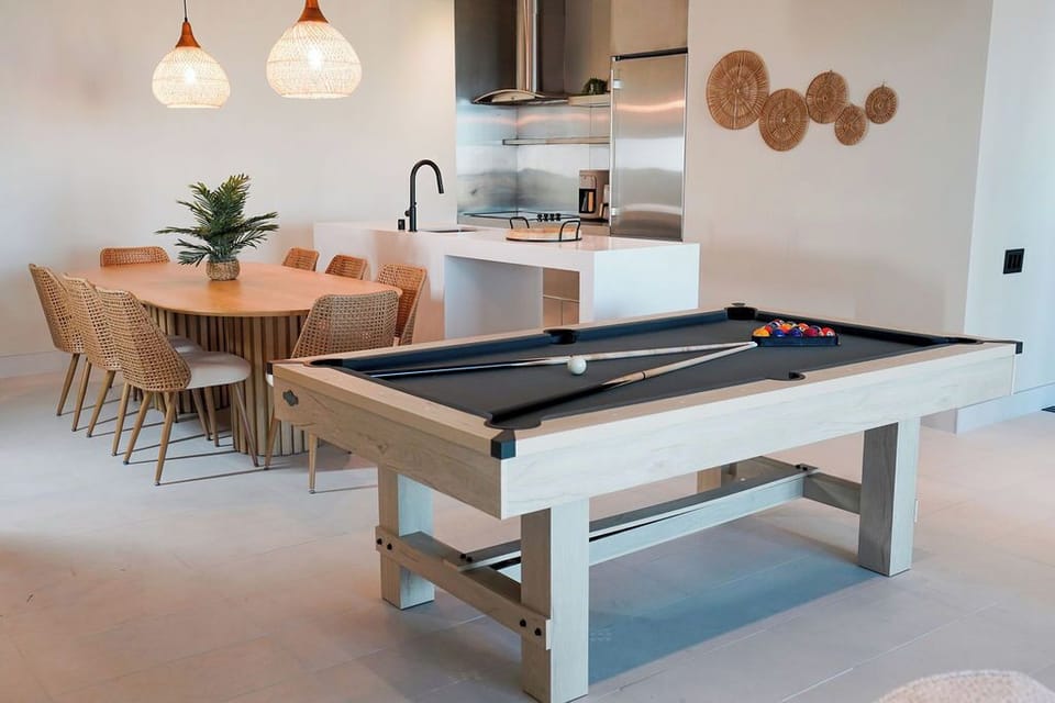 pro-style pool table as the centerpiece of an expansive open-concept layout.