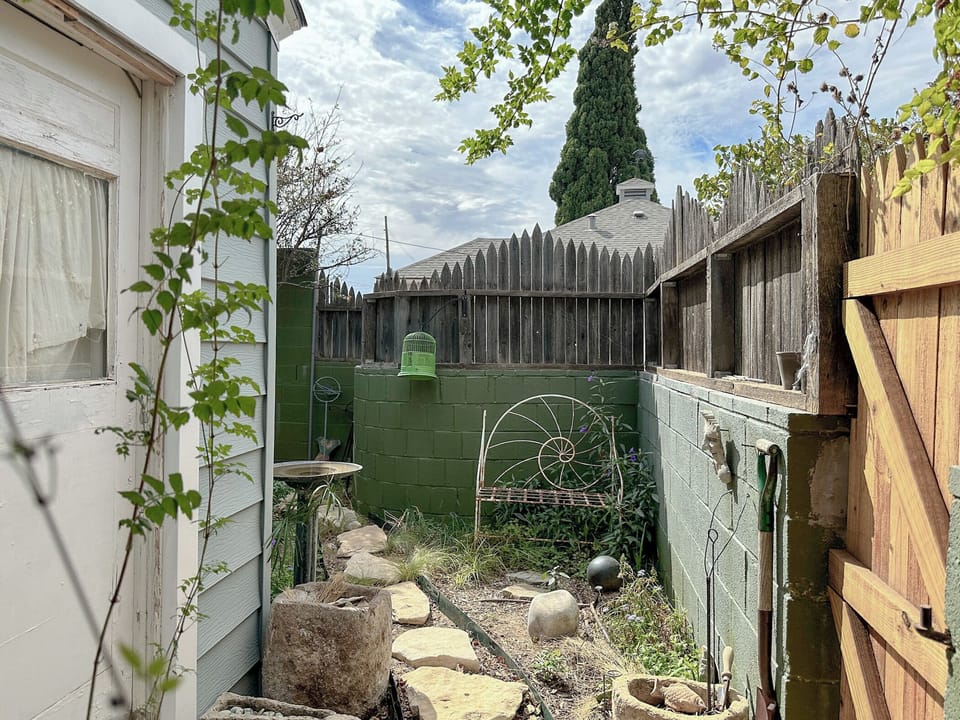 Back door and tiny private garden with a metal bench. Cushions in the closet.